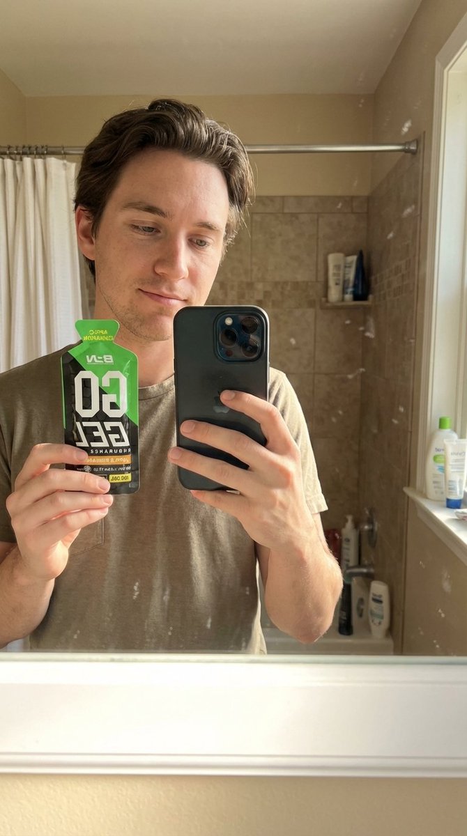 Create a hyper-realistic bathroom mirror selfie portrait where the person holds the product in one hand, lit by natural bathroom light with a believable handheld phone reflection in the mirror.