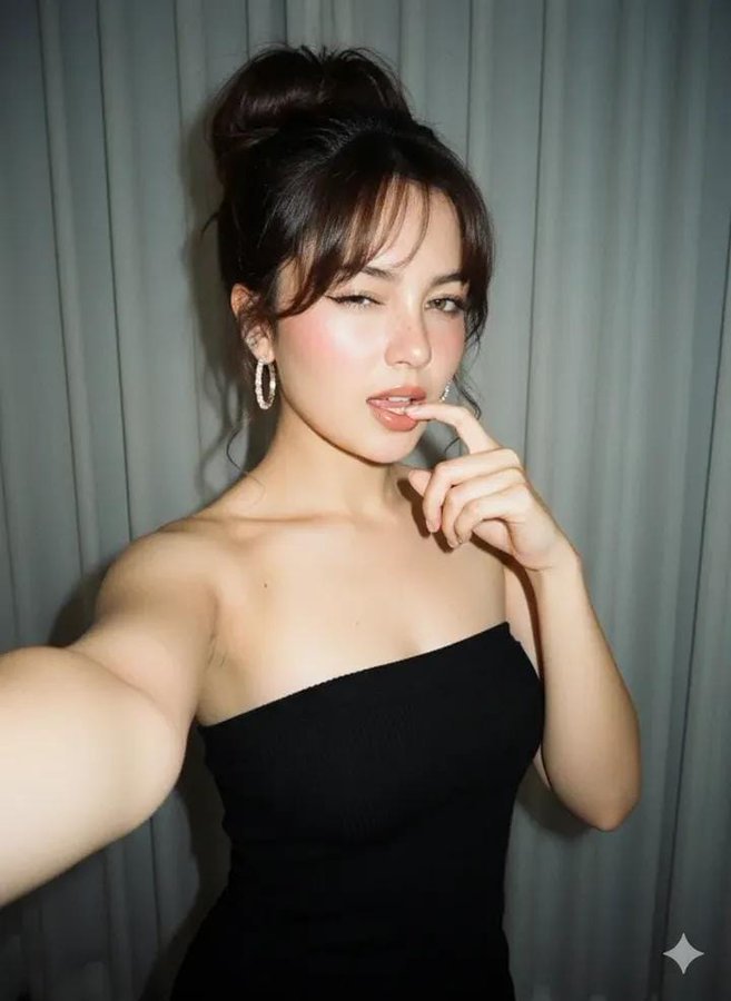 Create a close-up selfie portrait of a young woman posing flirtatiously in a room, lit by natural sunlight from the front against a soft grayish-white curtain backdrop. The look features natural makeup, freckles, diamond hoop earrings, and a strapless black knit mini dress with a vintage 90s camera aesthetic.