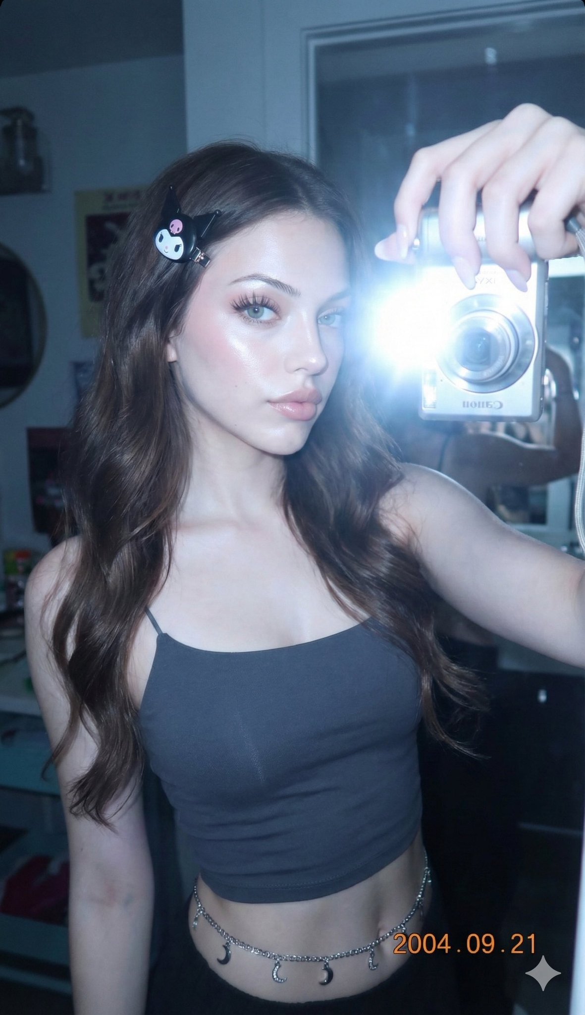 A teenage girl’s early-2000s Canon IXY/IXUS-style mirror selfie portrait with strong front flash, high contrast, and a slightly cool blue tone. The mirror reflection reveals another woman’s hand taking the photo, while the model’s face is preserved 100% unchanged.